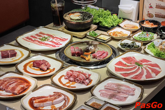 Bàn tiệc buffet lẩu nướng hấp dẫn với đa dạng thịt bò, heo, kim chi, cơm trộn và rau tươi bắt mắt.