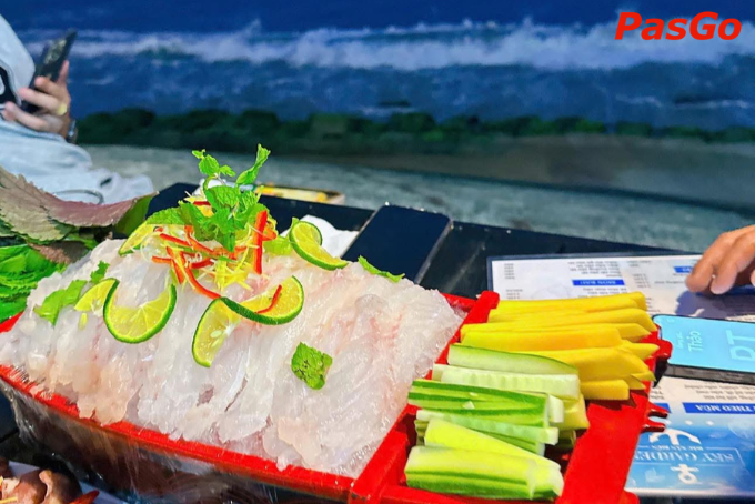 Sashimi tươi ngon được bày trí đẹp mắt trên bàn ăn ven biển